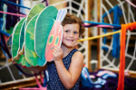 Child holding a caterpillar 3D puzzle at an exhibit at the Children's Museum of Pittsburgh